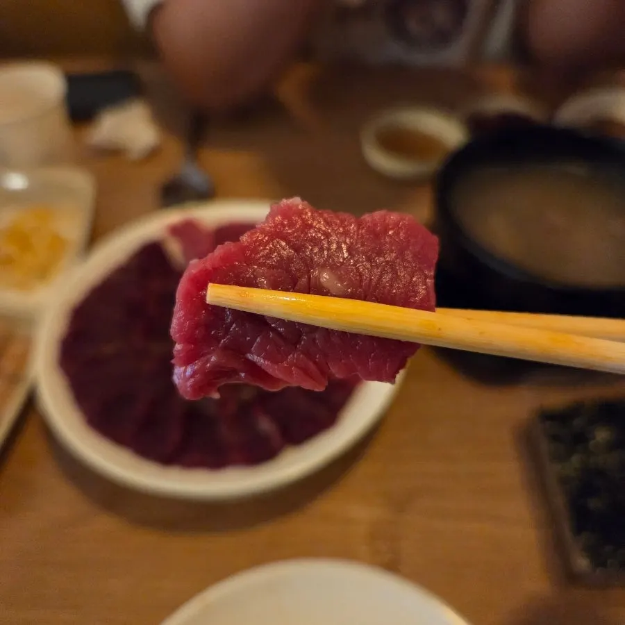 A piece of mungtigi dipped in sesame oil