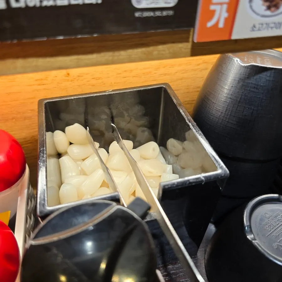 Sake poured into a glass alongside sushi