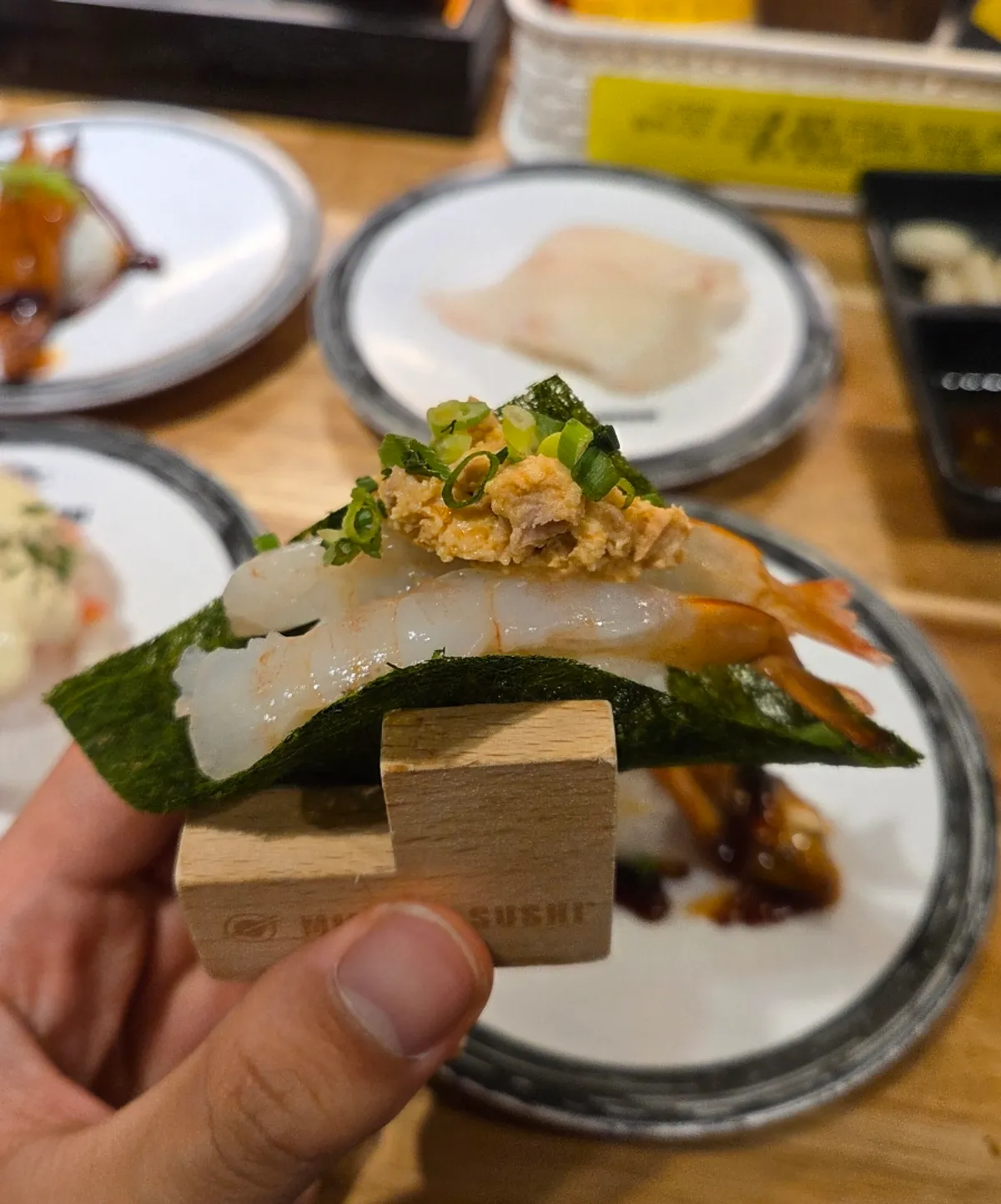 Second round of sushi plates spread across the table