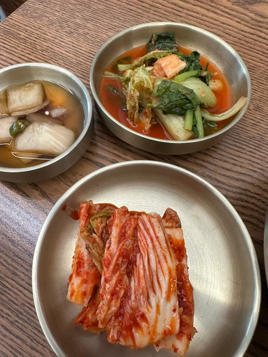 Table spread with mul makguksu, kal-mandutguk, and fried dumplings