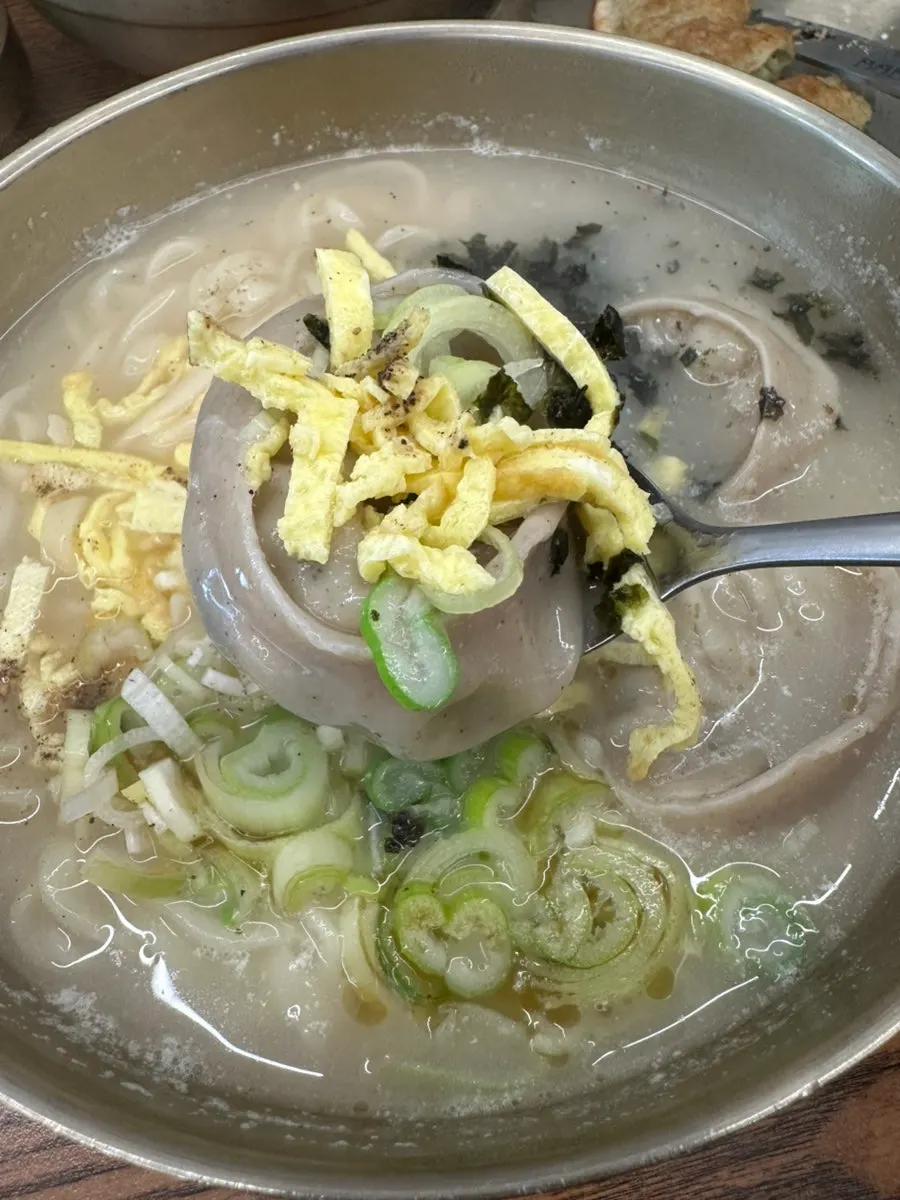 Ox bone kal-mandutguk topped with egg garnish and seaweed