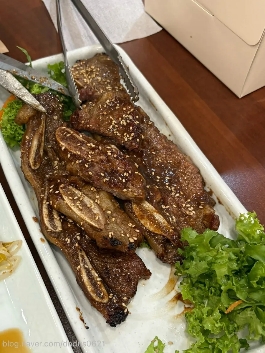 A piece of beef jeon topped with chive salad