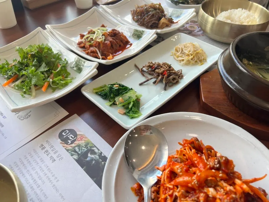 A plate of jellyfish salad and fresh kimchi side dishes