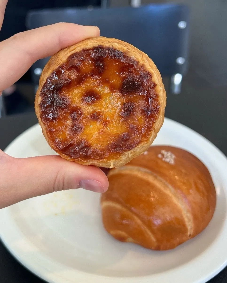 Portuguese-style egg tart with visible flaky layers