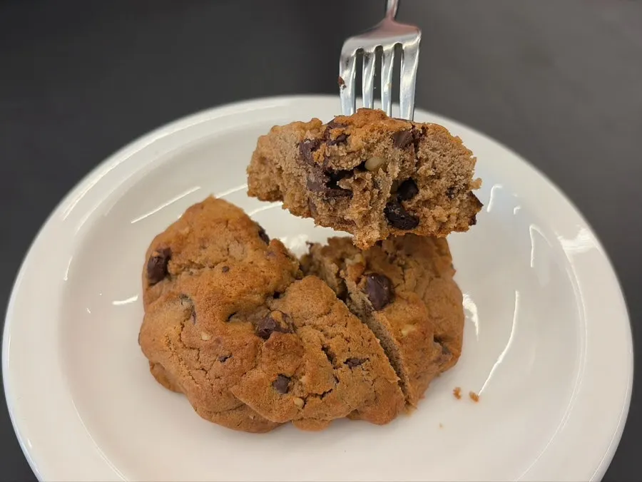 Cross-section of levain cookie packed with dark chocolate chips and walnuts