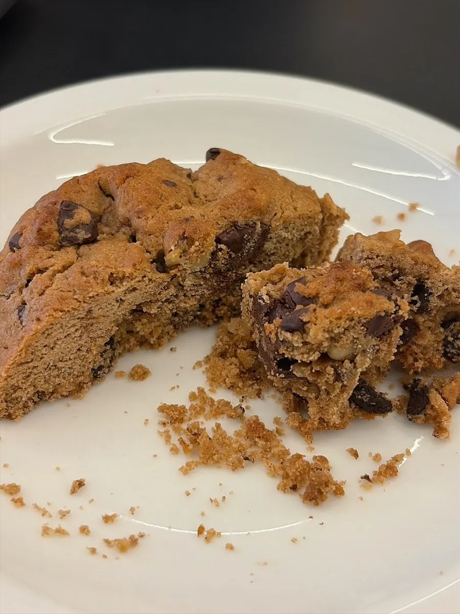 Vertical shot of levain cookie next to coffee