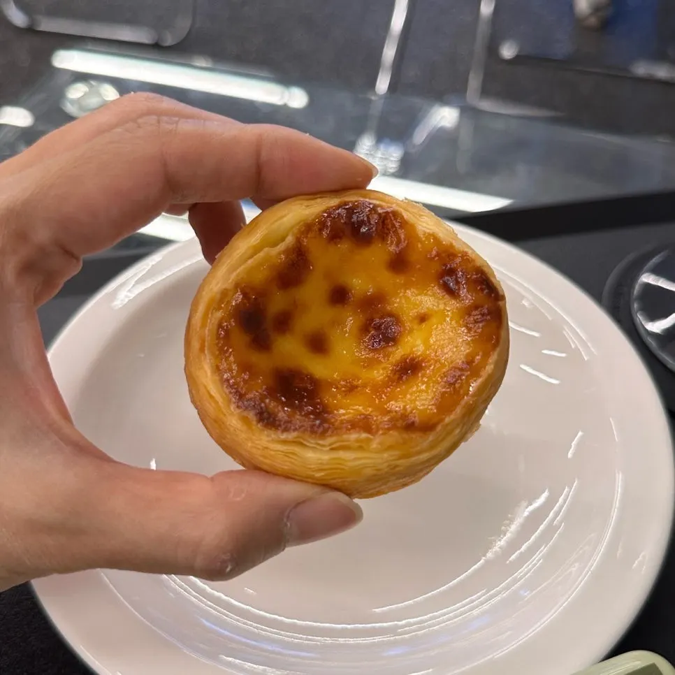 Egg tart held in hand for size comparison