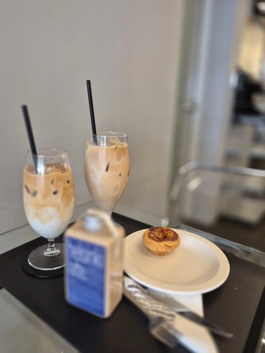 Table with Helsinki Latte, iced latte, and egg tart order