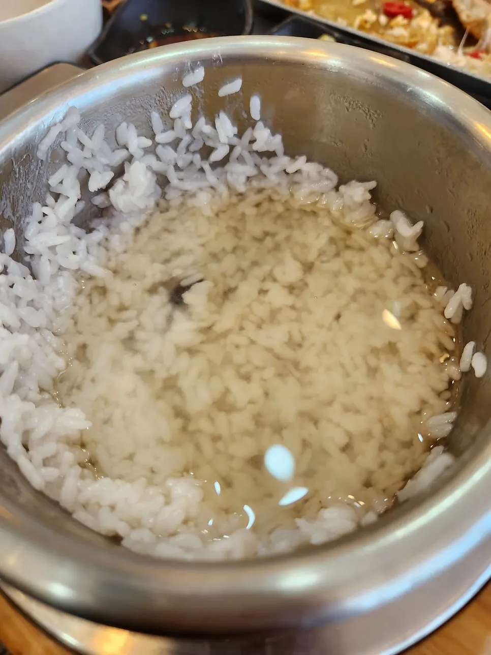 Bowl of scooped sotbap rice next to banchan
