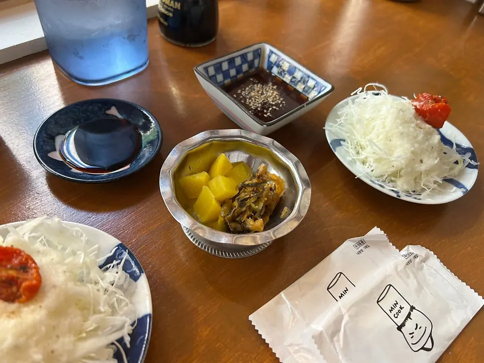 Basic table setting with salad, pickled radish, and aged kimchi