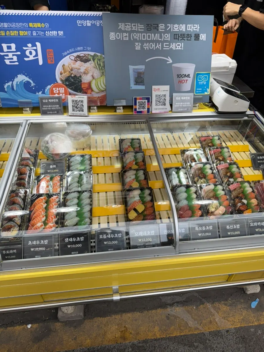 Staff member managing the sushi display case