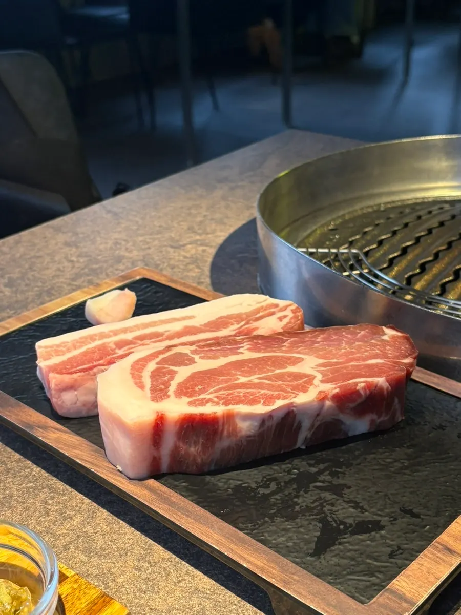 Plate of well-marbled pork neck and dry-aged pork belly