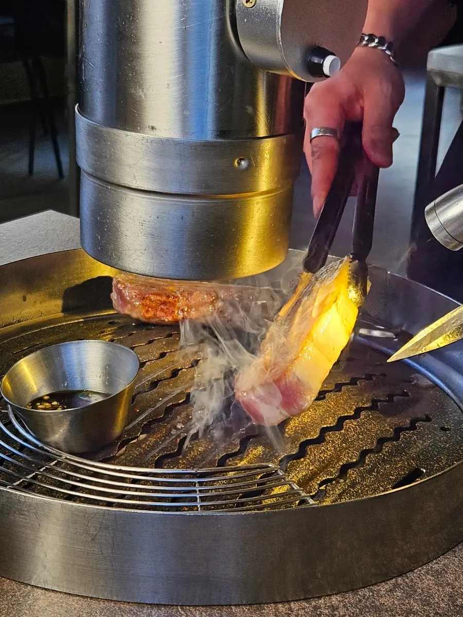 Meat cooking on the grill with side dishes