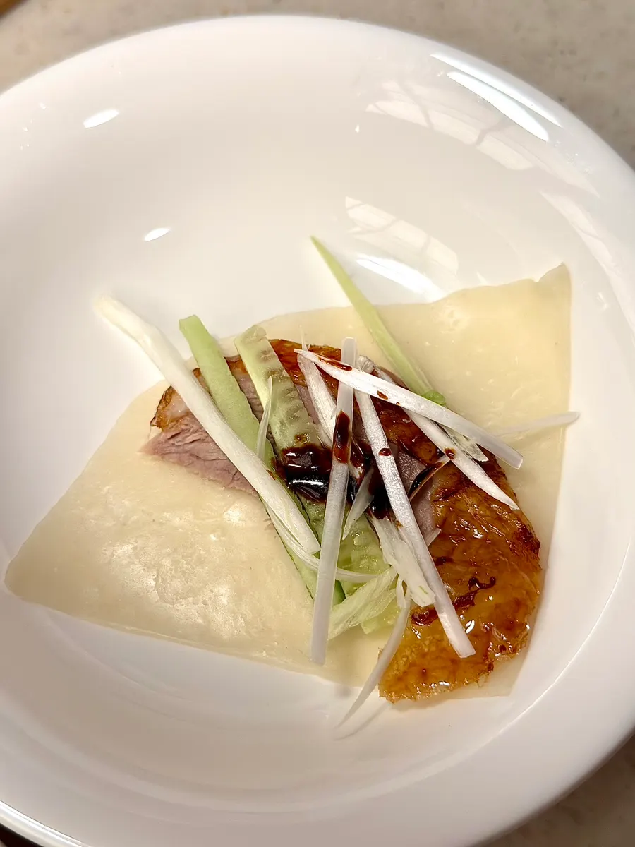 A finished Peking duck wrap in a wheat pancake