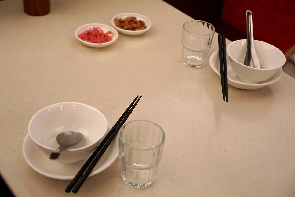 Small plates, utensils, peanuts and beansprout-beet pickle side dishes