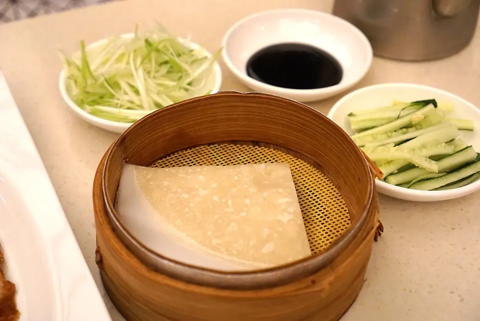 Peking duck and vegetables placed on a thin pancake