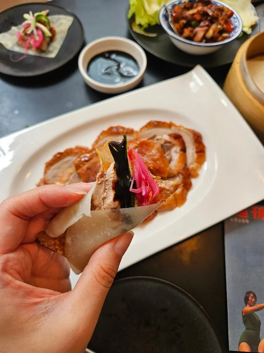 A piece of Peking duck dipped in sauce