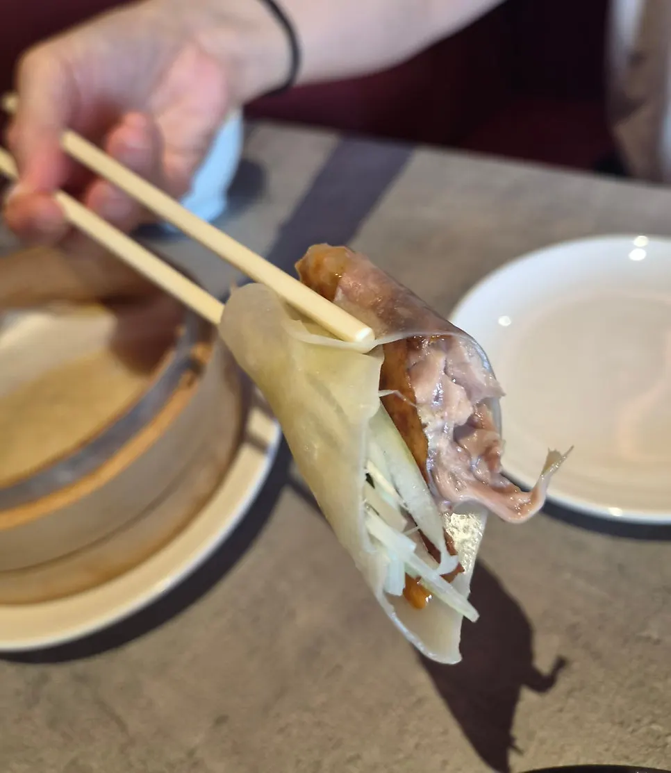 A finished Peking duck wrap in a wheat pancake