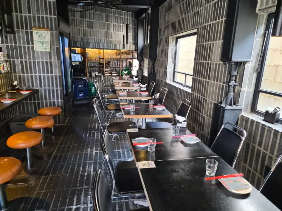 Dimly lit interior with counter and table seating at Mirim Yangjang
