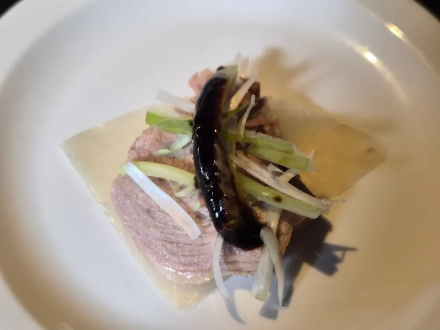 A finished bite of Peking duck wrapped in pancake