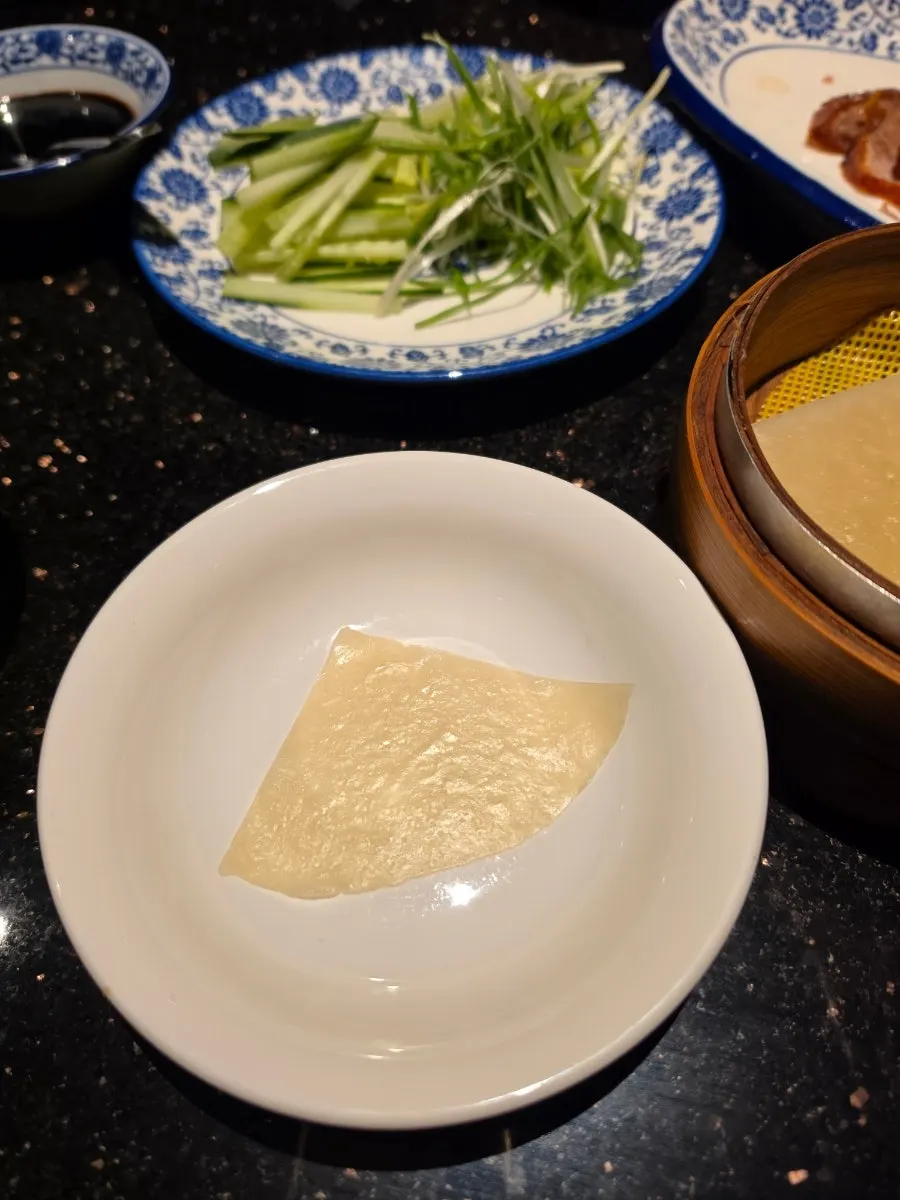 Duck meat and scallion piled onto a pancake
