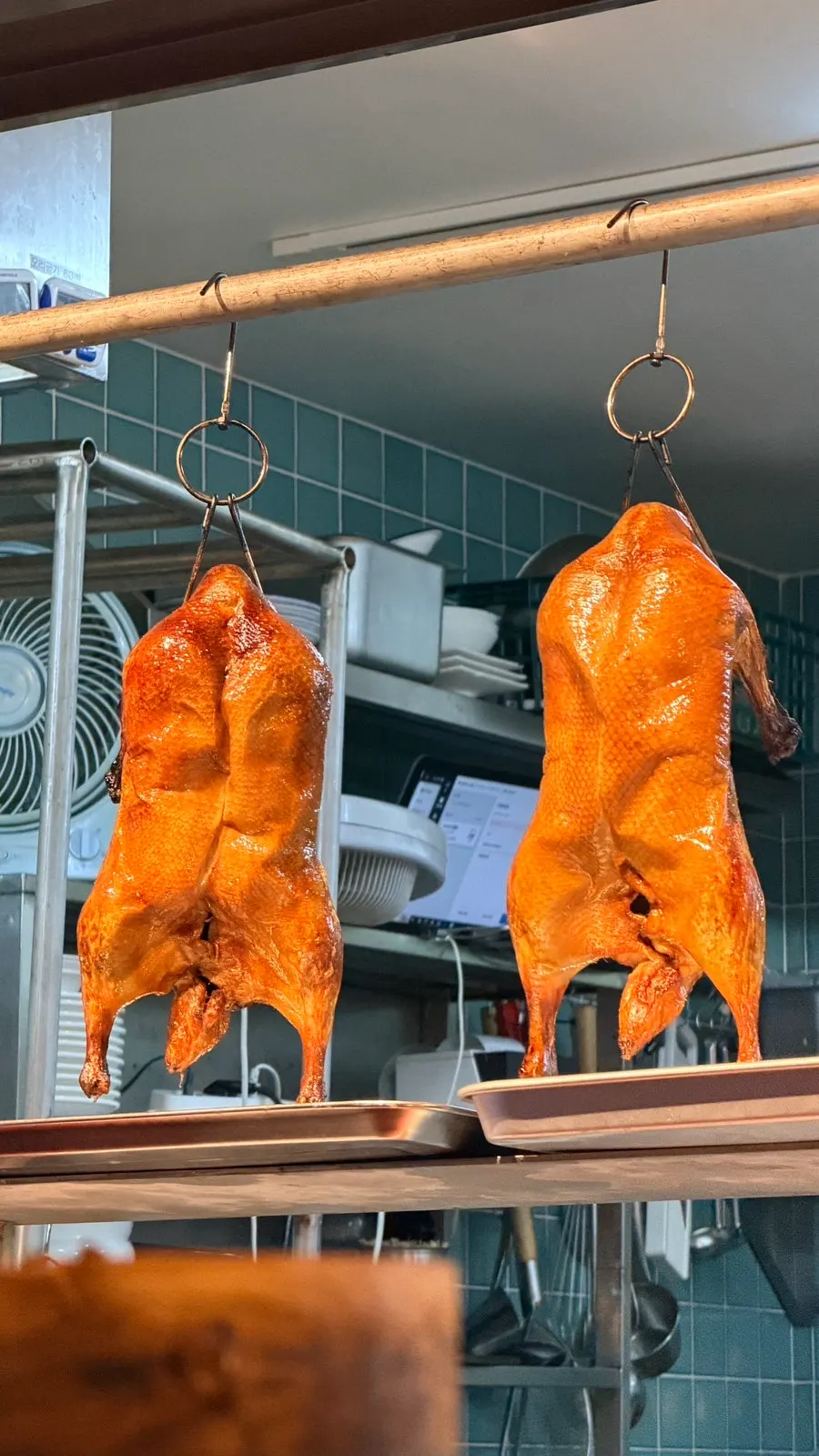 Peking ducks hanging in a corner of the restaurant
