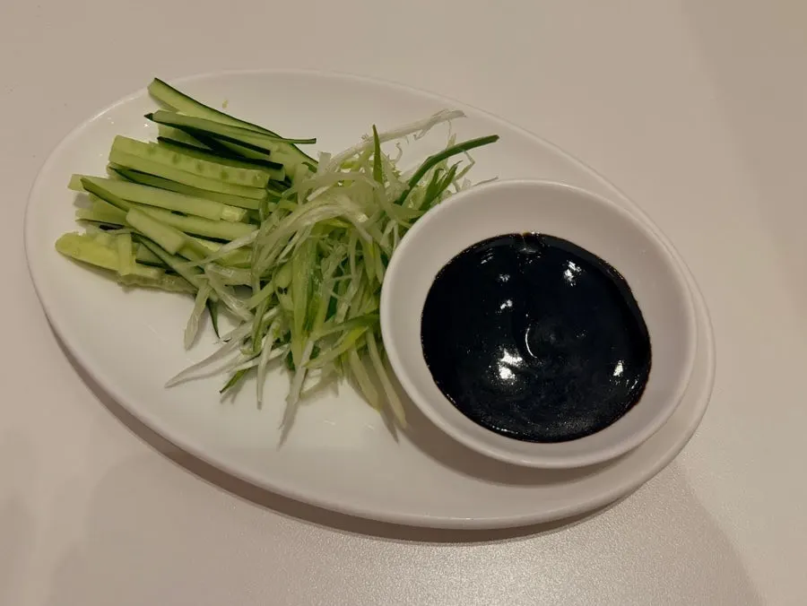 Brushing sauce onto a Peking duck wrap in progress