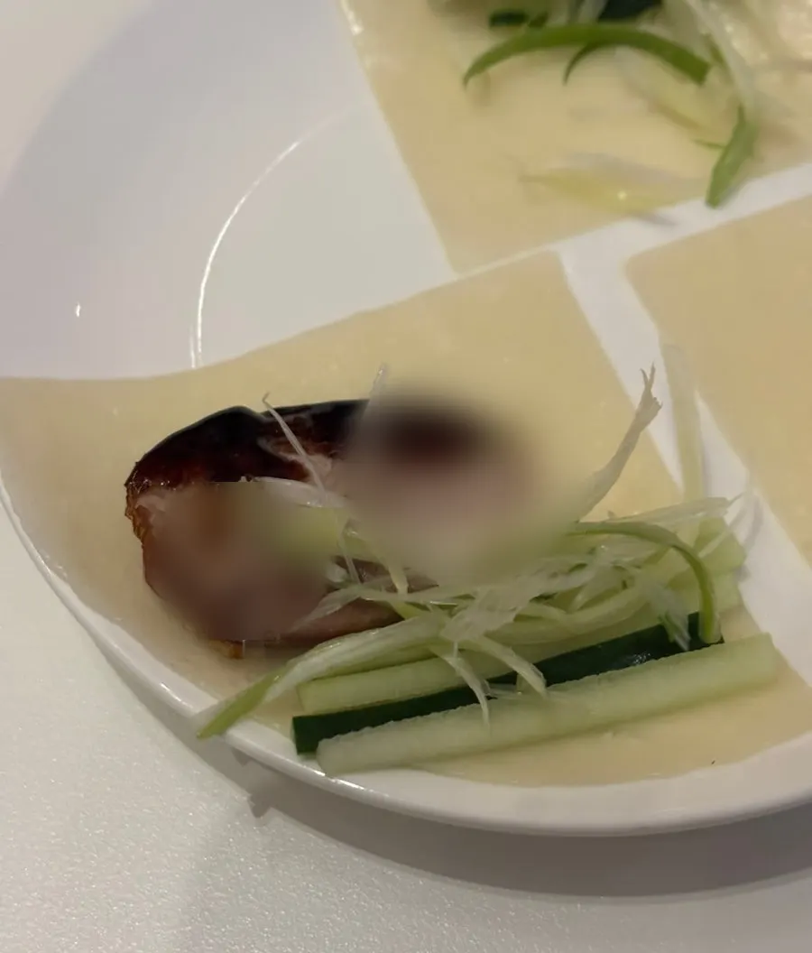 Wrapping duck meat and vegetables in a pancake to eat