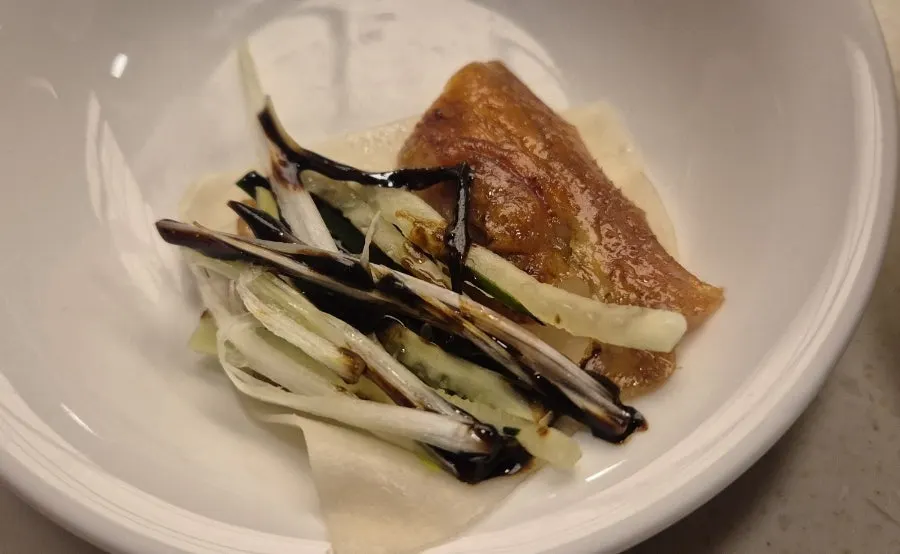 Plate of half Peking duck with bigger cuts of skin