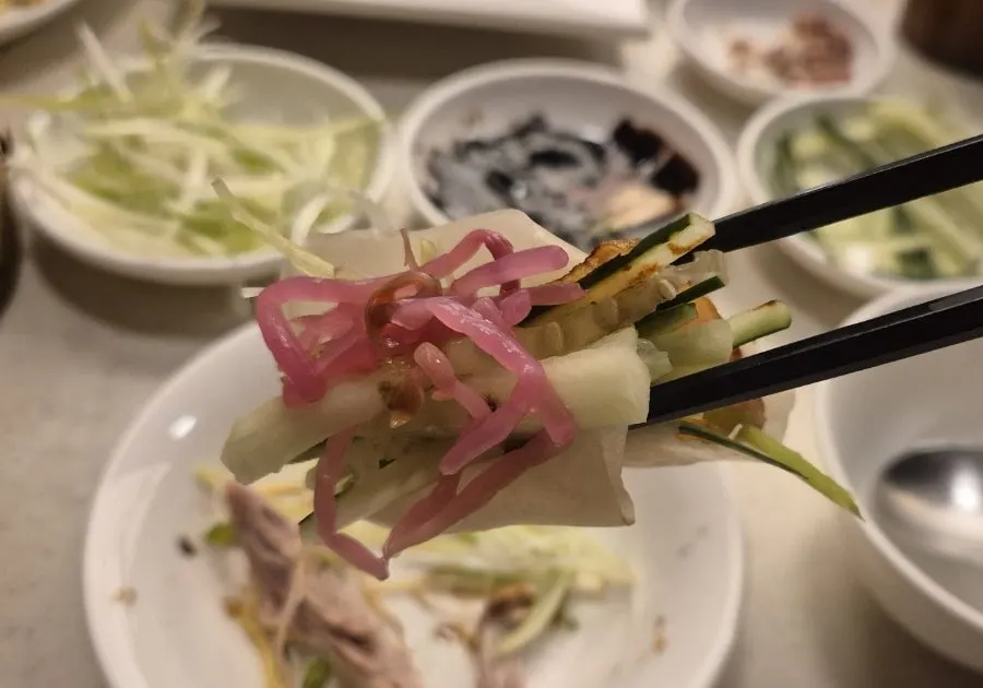 Duck, scallion strips, and cucumber wrapped in a wheat pancake