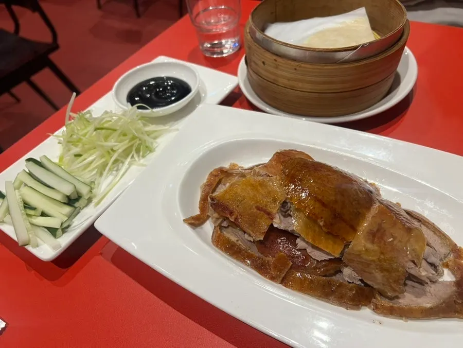 Peking duck served with wheat pancakes, cucumber, and scallion strips