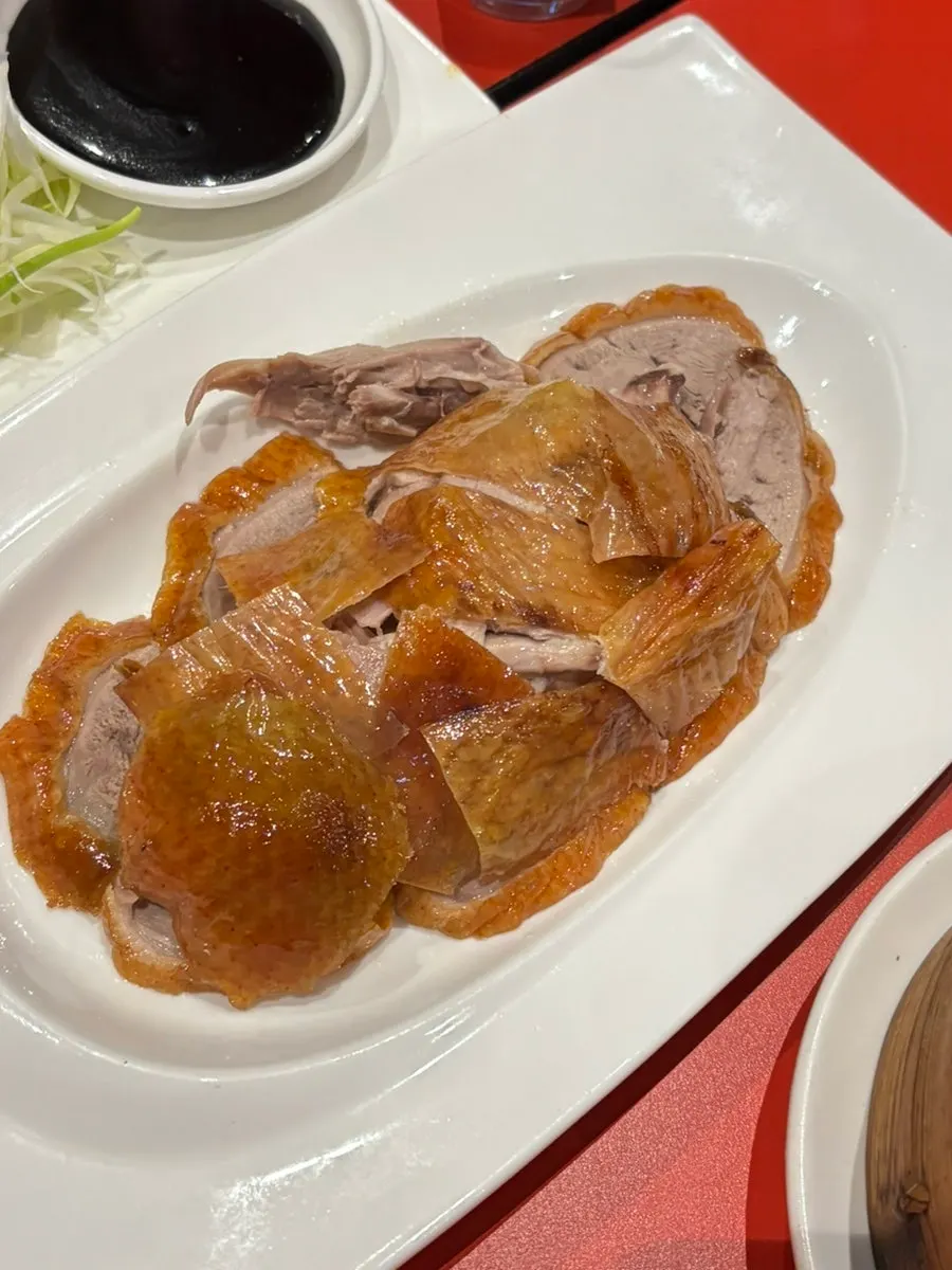 Peking duck pancake wrap eaten with scallion strips