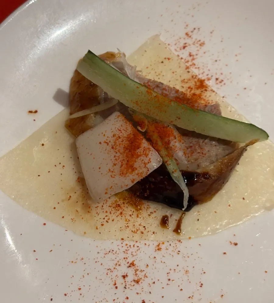 Peking duck table setting with pancakes, cucumber, and onion