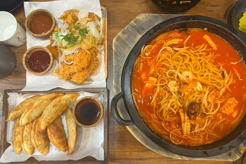 Table spread of the stone jjamppong set, donttang & chitang, and fried dumplings