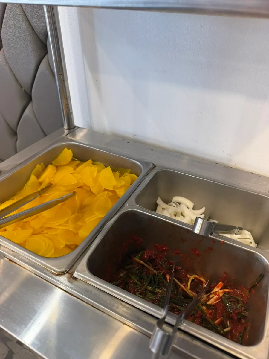 Self-serve bar with pickled radish, green onion kimchi, and onions