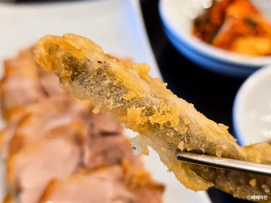 김치를 올려 먹은 수육 한 점