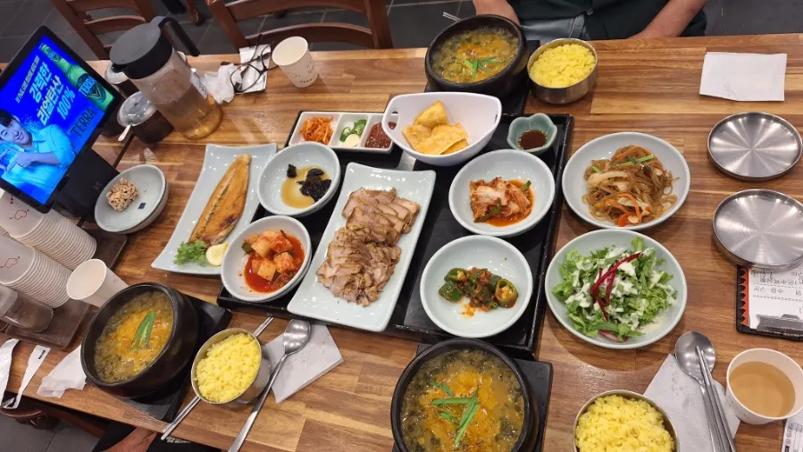 Full table spread with loach soup, boiled pork, and grilled mackerel