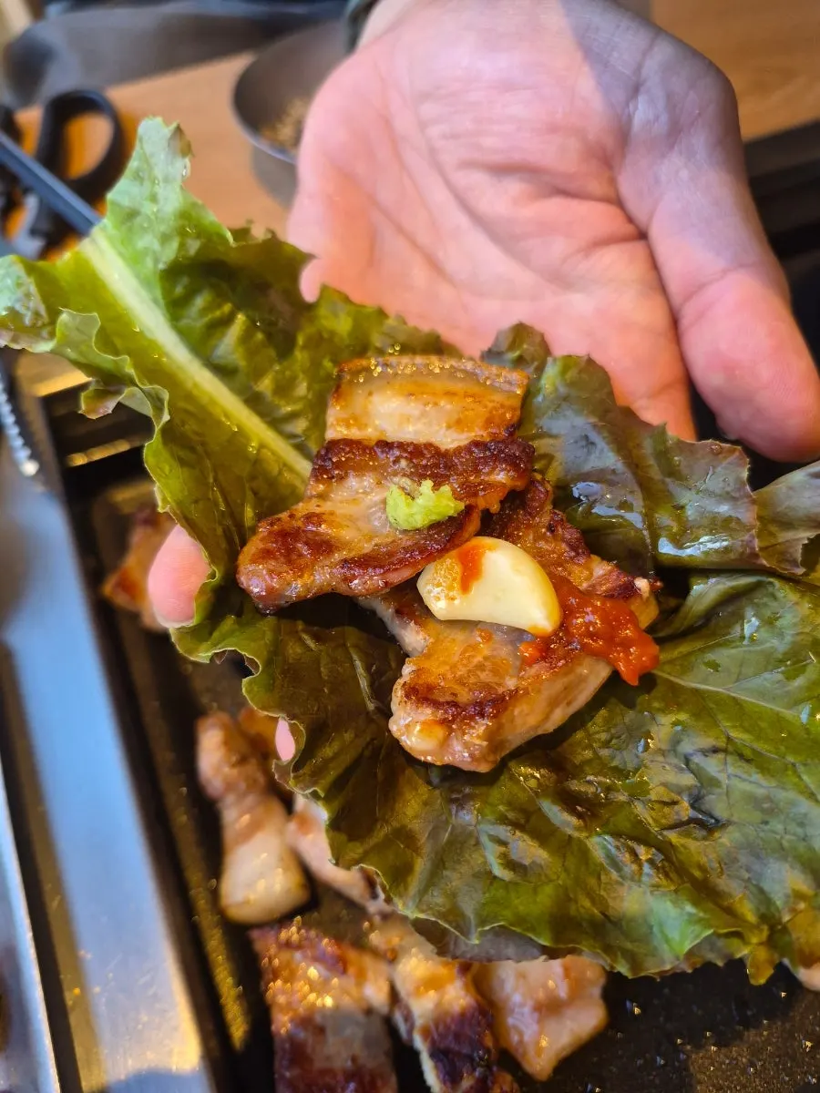 Pork belly on the grill plate with side dishes