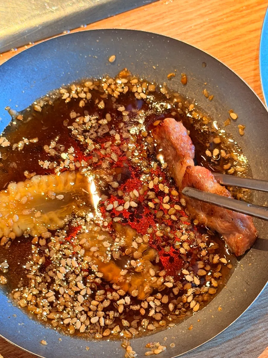 A piece of grilled pork belly dipped in sauce