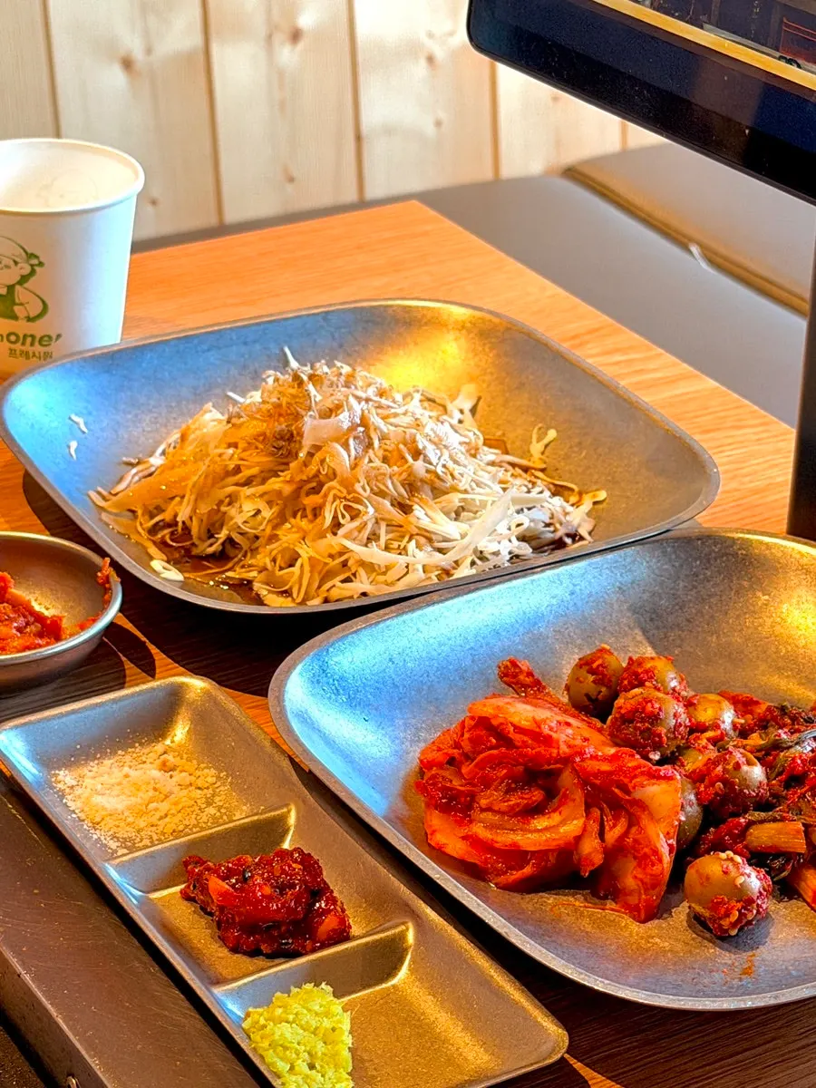 Cabbage salad topped with olive kimchi and tiny anchovies