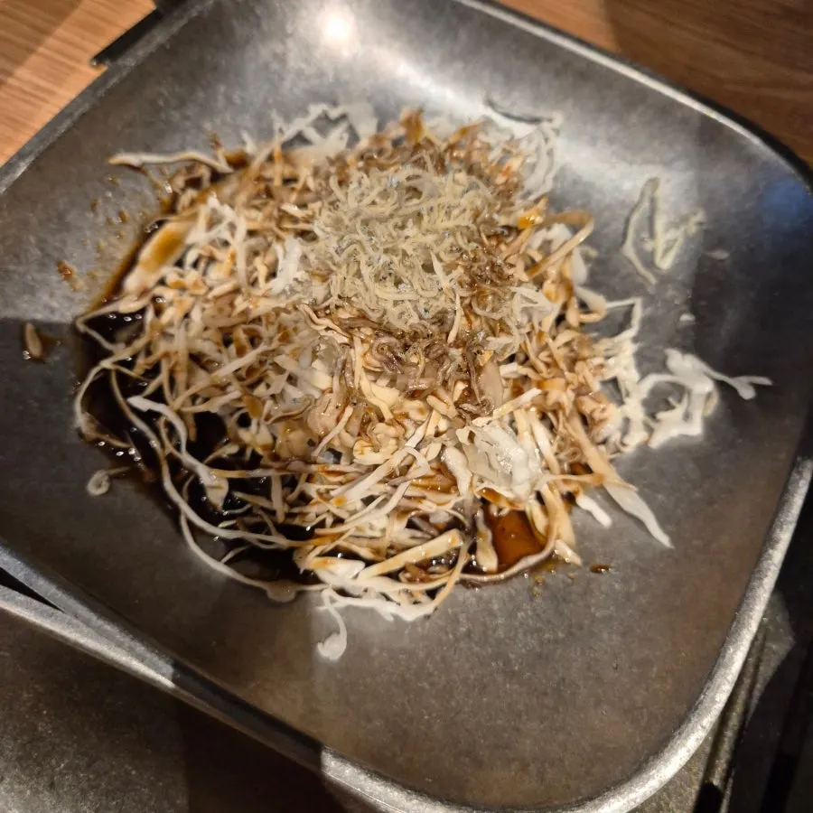 멸치가 올려진 샐러드와 찬