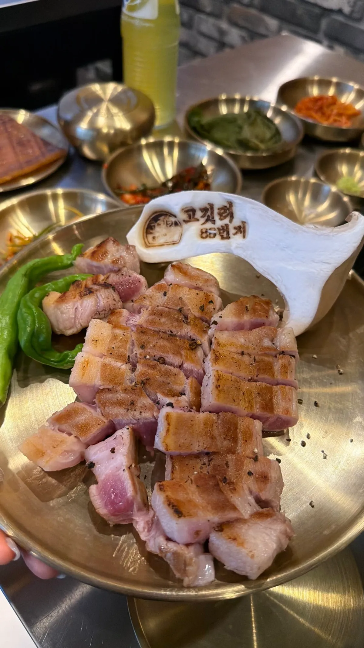 Par-seared pork neck and pork belly grilling over charcoal