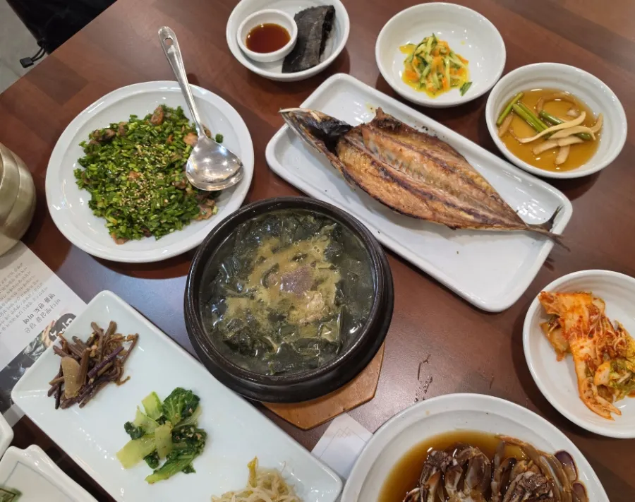 Table with grilled mackerel and side dishes laid out