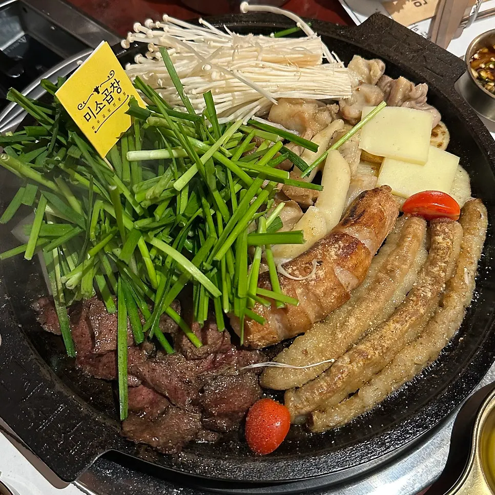 Grilled platter topped with vegetables and rice cake sticks