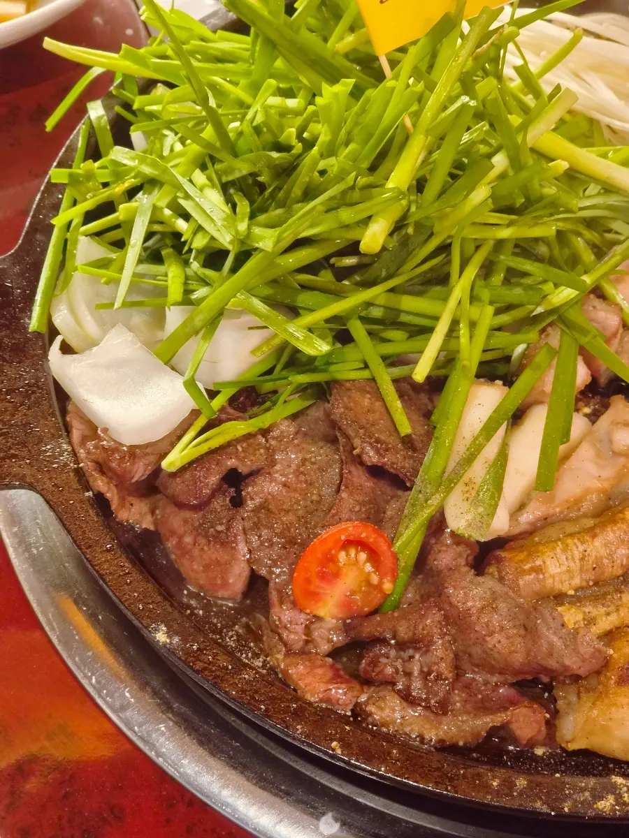 Grilled gopchang topped with enoki mushroom, chives, and cheese