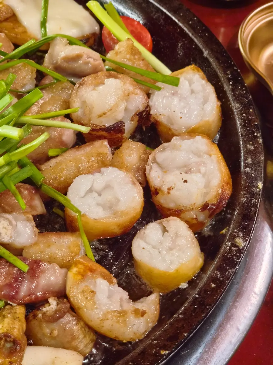 A piece of Korean beef gopchang dipped in sauce