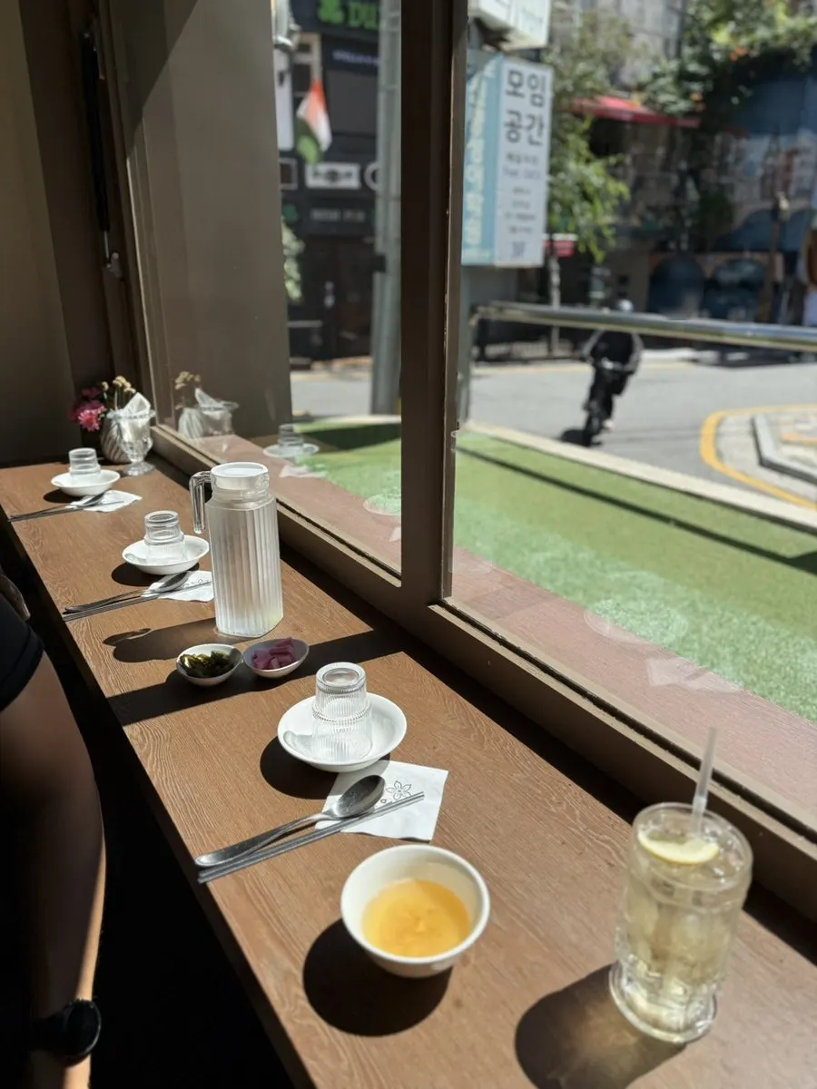Couple sitting side by side at a window date seat at Moa Gangnam