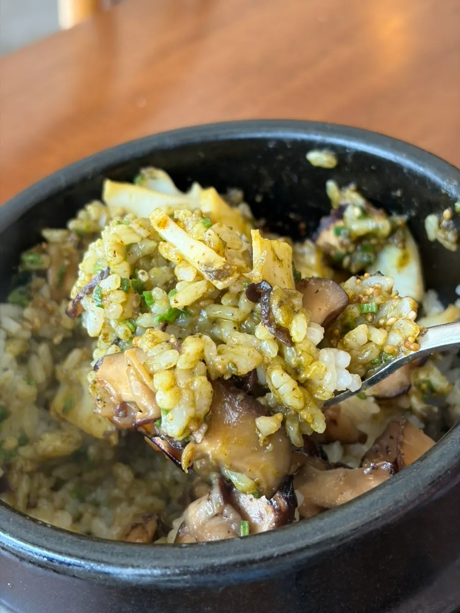 A spoonful of pot rice topped with abalone