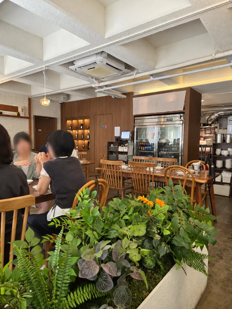 Wood-toned tables and plants inside the restaurant