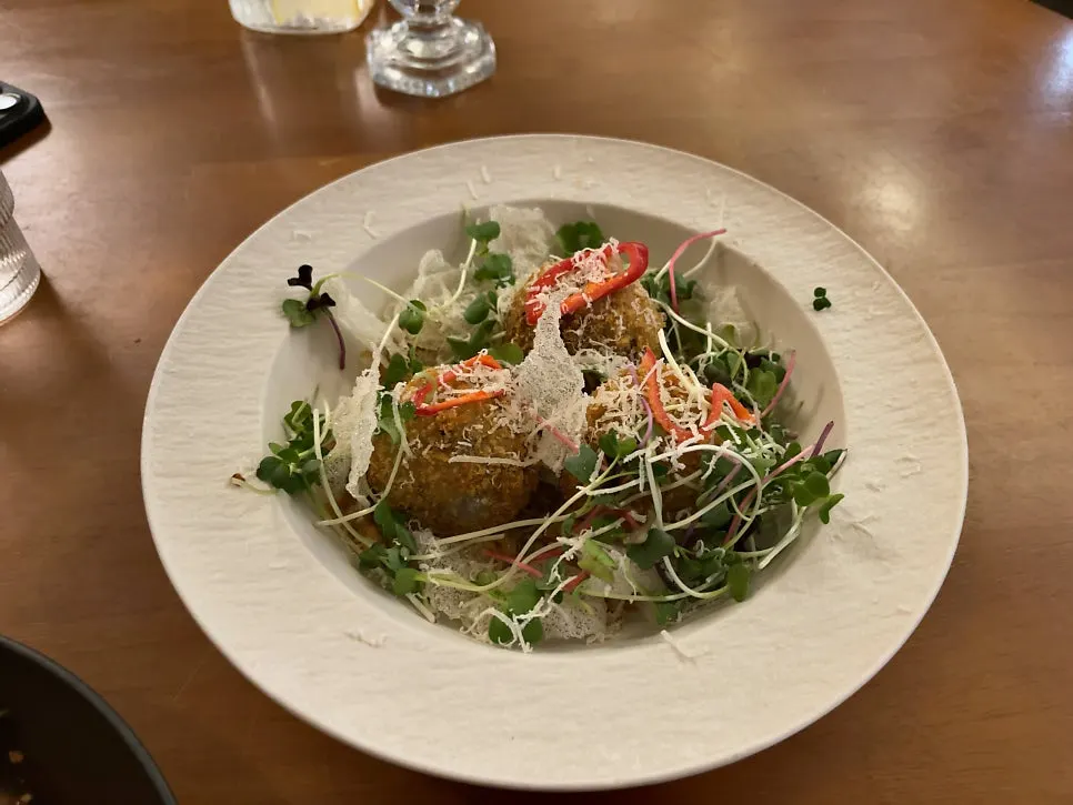 Three barley doenjang arancini balls lined up on a plate
